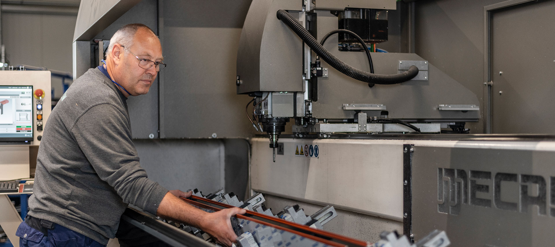 Mitarbeiter bei der CNC-Bearbeitung von Aluminiumprofilen im Metallbau