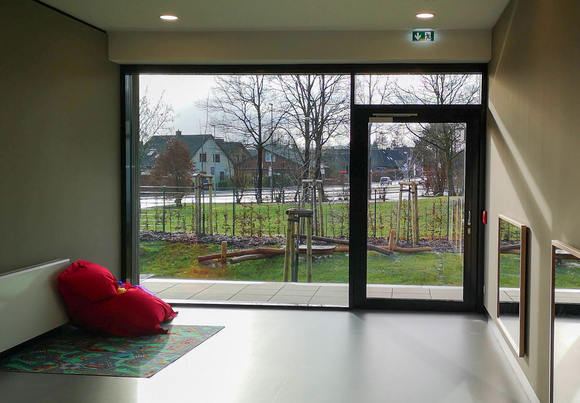 Innenansicht des Neubaus der Krippe St. Anna in Wallenhorst mit großflächiger Aluminium-Glasfassade und Tür von Klövekorn Metall