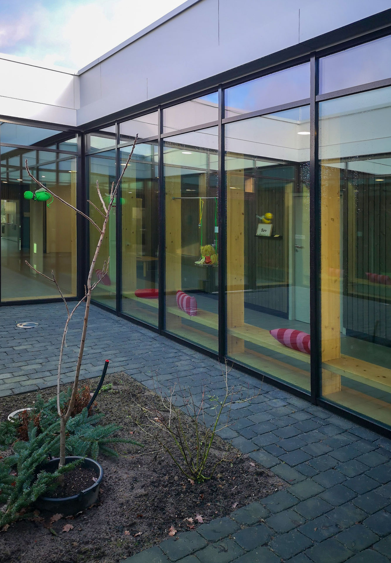 Innenhof des Neubaus der Krippe St. Anna in Wallenhorst mit Aluminium-Pfosten-Riegelfassade von Klövekorn Metall