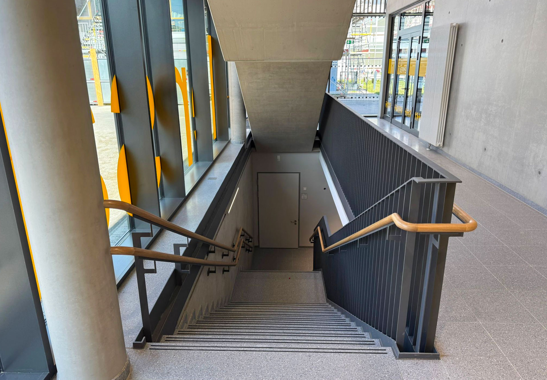 Treppe mit Metallgeländer und Holzhandlauf in der Norbertschule Münster