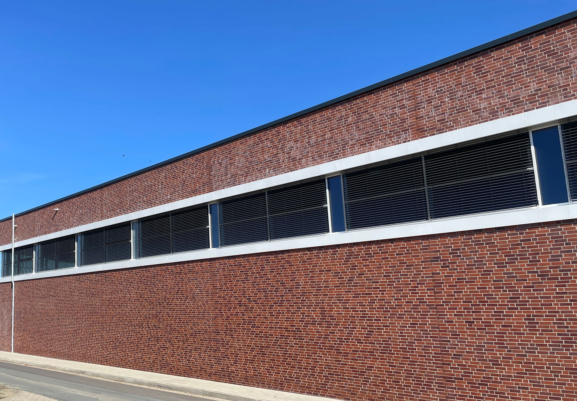 Fassadenelemente und Aluminiumfenster an der Sporthalle Badbergen